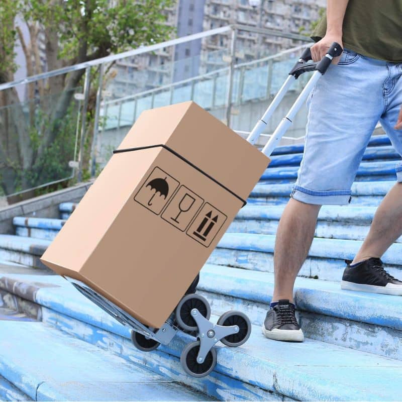 picture of a man pulling the ALL TERRAIN MULTIFUNCTIONAL STAIRS CLIMBING CART. He is carrying some boxes on it